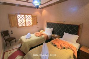 伊姆利尔Gite Ghazal - Atlas Mountains Hotel的一间卧室配有两张带毛巾的床