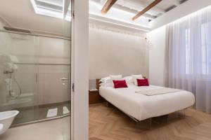 罗马Poēsis Experience Hotel的白色卧室配有一张床和淋浴