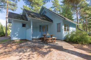 波里Yyteri Holiday Cottages的蓝色房子前面设有野餐桌