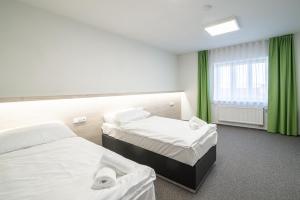 苏希采Garni hotel Roušarka的酒店客房设有两张床和窗户。