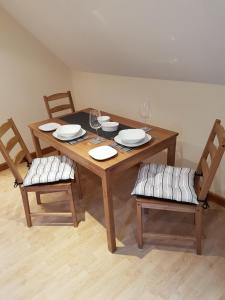 阿伯加文尼The Loft Apartment的木桌、带盘子的椅子和酒杯