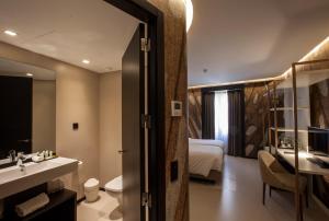 里斯本Hotel Pateo - Lisbon Lounge Suites的一间带水槽、床和镜子的浴室