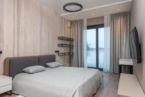 VishenkiRiviera Zoloche Resort & Spa的一间卧室设有一张大床和一个大窗户