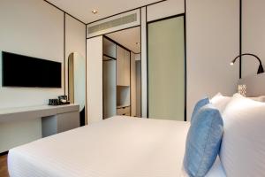 迪拜Lemon Tree Hotel, Jumeirah Dubai的卧室配有一张白色大床和电视。