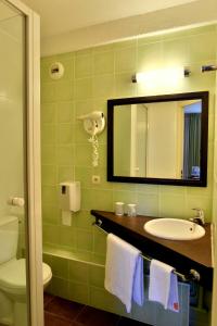 拉若瓦尔Hôtel Inn Chambéry的一间带水槽、镜子和卫生间的浴室