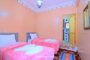 伊姆利尔Hotel Aremd - Aroumd Imlil route du Toubkal的配有粉红色墙壁的客房内的两张床