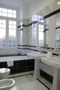 库里亚Curia Palace Hotel & Spa的一间带两个盥洗盆、淋浴和卫生间的浴室