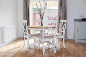 BlidworthRaynolds Cottage Blidworth的白色的餐桌,配有两把椅子和一张白色的桌子及椅子
