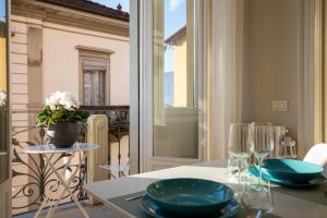 韦尔巴尼亚Aqualago casa vacanze apartment D的阳台上配有带蓝板和玻璃杯的桌子