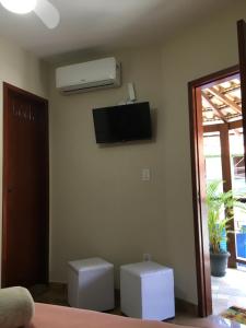 阿拉亚尔-杜卡布Varandas do Atalaia Suítes的客厅的墙上配有空调
