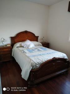 洛维奥斯Secondary home的一间卧室配有一张大床和木制床头板