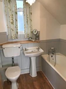 格兰奇奥沃桑茨Inglenook Cottage的浴室配有卫生间、盥洗盆和浴缸。
