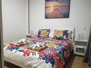 Playa del BurreroBRISAS DEL MAR APARTMENT, ONE STEP FROM THE SEA.的床上配有色彩缤纷的被子和枕头