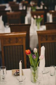 赫讷福斯赫尼夫斯上豪大饭店的一张桌子上放着花瓶和蜡烛