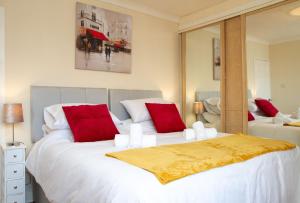格兰奇茅斯Carvetii - Derwent House - Spacious 2nd floor flat的一间卧室配有两张带红色枕头的大床