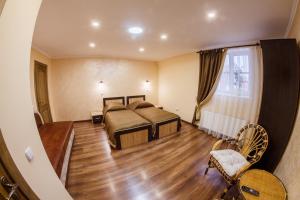卡缅涅茨-波多利斯基Panorama Apart-Hotel的一间卧室设有两张床,铺有木地板