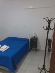 布兰卡港Roberta 3的一间卧室配有一张蓝色的床和一张黑色的极子