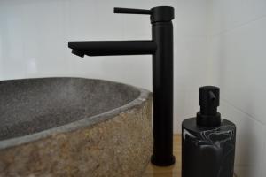 Tapu蒂玛塔小屋旅馆的浴室水槽和柜台上的黑色水龙头