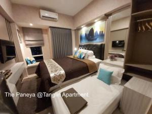 泗水The Paneya @Tanglin Apartment的酒店客房带两张床和一间浴室