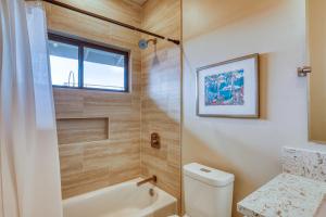 瓦克拉Waikoloa的带浴缸、卫生间和窗户的浴室