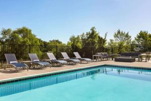 大学城La Quinta Inn & Suites by Wyndham College Station North的一个带躺椅和一排排排酒的游泳池