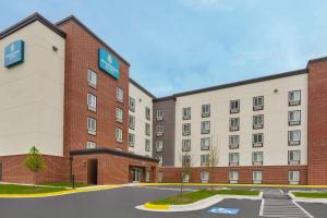 绿带城WoodSpring Suites Washington DC Northeast Greenbelt的停车场酒店 ⁇ 染