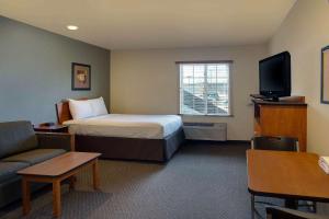 坎普泉WoodSpring Suites Washington DC Andrews AFB的一间酒店客房,配有一张床和一台电视