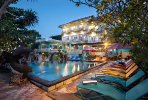 蓝梦岛The Tanis Beach Resort Nusa Lembongan的一个带躺椅的游泳池和一间酒店
