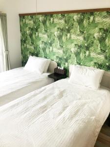 福冈ラ・ポート空港前201的一间卧室设有两张床和绿色的墙壁