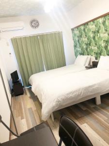 福冈ラ・ポート空港前201的卧室配有一张白色大床和一把椅子