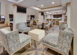 圣安东尼奥Holiday Inn Express & Suites San Antonio Brooks City Base, an IHG Hotel的餐厅内带桌椅的等候区