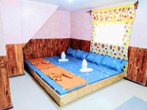 MabubuaBlue Lagoon Inn and Restaurant的客房设有一张带蓝色床单的床和窗户。