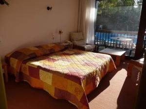 孔东德科德利埃乐家酒店的一间卧室配有一张带彩色毯子的床