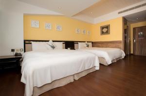 垦丁大街承亿文旅垦丁雅客小半岛的配有白色床单的酒店客房内的两张床