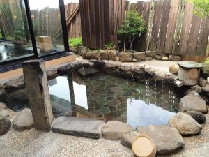 秋田多美迎秋田酒店的后院的游泳池,带围栏和池塘