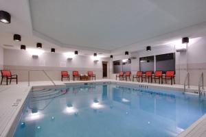 渥太华渥太华东奥尔良智选假日套房酒店的一个带红色椅子和桌子的大型游泳池