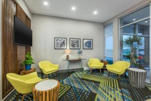 蒙克顿蒙克顿智选假日酒店的一间设有黄色椅子和平面电视的等候室