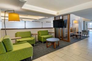 珊瑚角珊瑚角 - 迈尔斯堡地区智选假日酒店的客厅配有绿色家具和平面电视