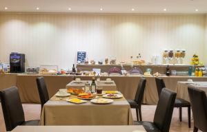 塞奥-德乌赫尔Hotel Andria的一间餐厅配有桌椅,提供食物