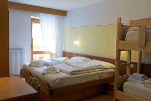 拉比Alpen Hotel Rabbi的一间卧室设有两张双层床和一张桌子