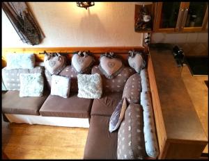 普华露Appartement chalet PRA LOUP 1600 La sapinière的客房内的棕色沙发上配有枕头