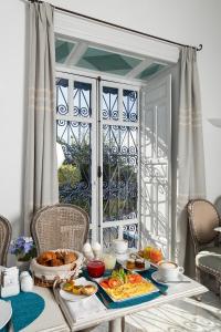 西迪·布·赛义德达累斯萨拉姆酒店的一张桌子,上面有早餐食品,窗户