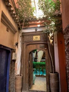 马拉喀什Riad Ghali Hotel & SPA的一座带植物门的建筑的入口