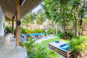 新孔DHYANA VILLAS的后院设有游泳池和带蓝色枕头的花园
