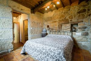 奥伦塞Gran Casa Rural A Touza的卧室配有一张石墙床