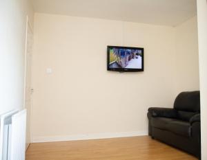 格兰奇茅斯Carvetii - Derwent House - Spacious 2nd floor flat的客厅配有沙发和墙上的电视
