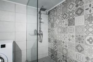 雅典Omnia Pagrati Apartments的浴室里设有玻璃门淋浴