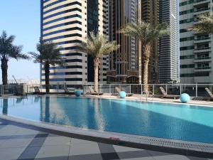 迪拜Icon Casa Living - Torch Tower Dubai Marina的一座棕榈树和高楼游泳池