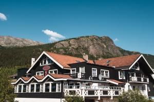海姆瑟达尔海姆瑟达尔咖啡滑雪者小屋酒店的一座黑色的大建筑,背景是一座山