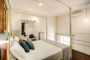那不勒斯Casa Hosteno的卧室配有带枕头的大型白色床